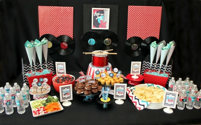 Fiesta de los años 50 con muchos dulces. Decoración de discos de vinilo y un tambor