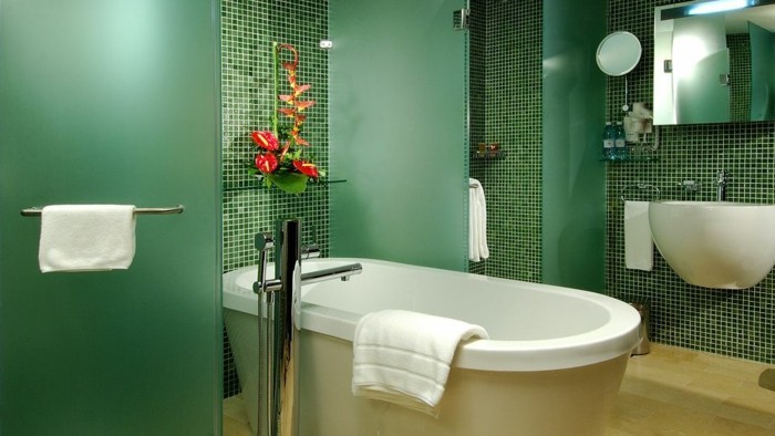 Λουτρά-χωρίς-πλακάκια-με-πράσινο-γυάλινους τοίχους και-λουλούδια-ως-διακόσμηση