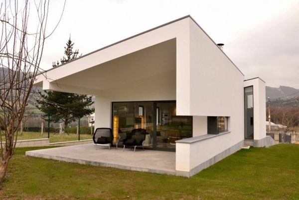 Fachada blanca y sillón con vistas al campo para un sorprendente diseño hogareño