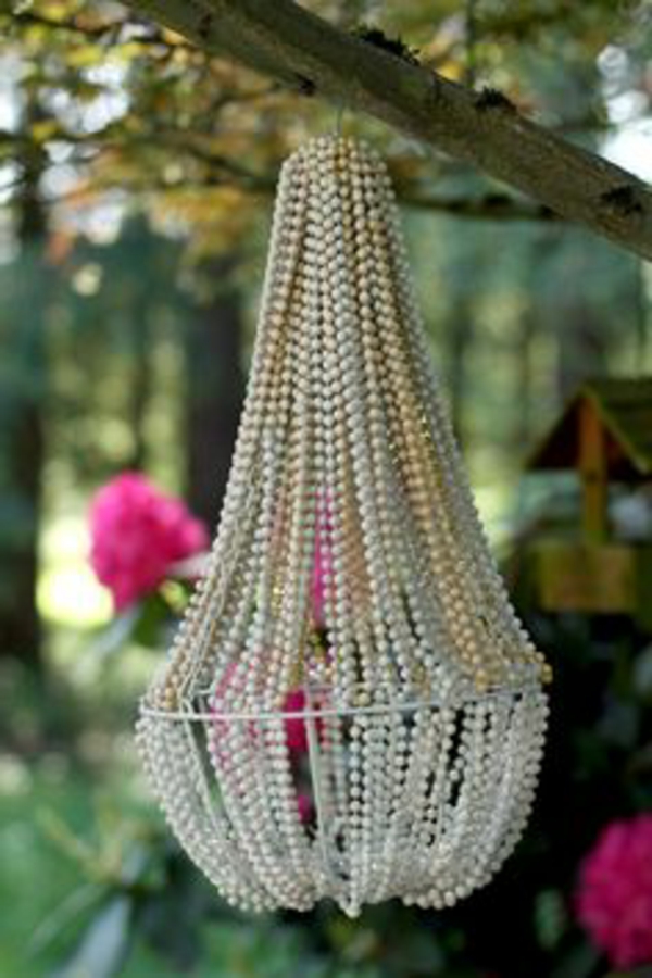 DIY-lamppu valmistettu helmi kaulakoruista - roikkuu puun oksasta
