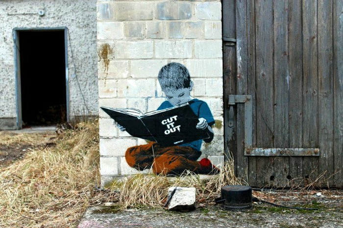Grange graffiti mur de briques Boy lecture du livre
