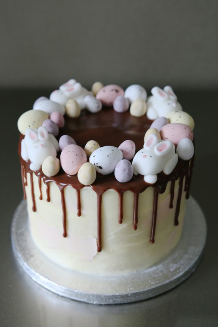 装饰复活节蛋糕与巧克力液体和五颜六色的小杏仁饼复活节彩蛋