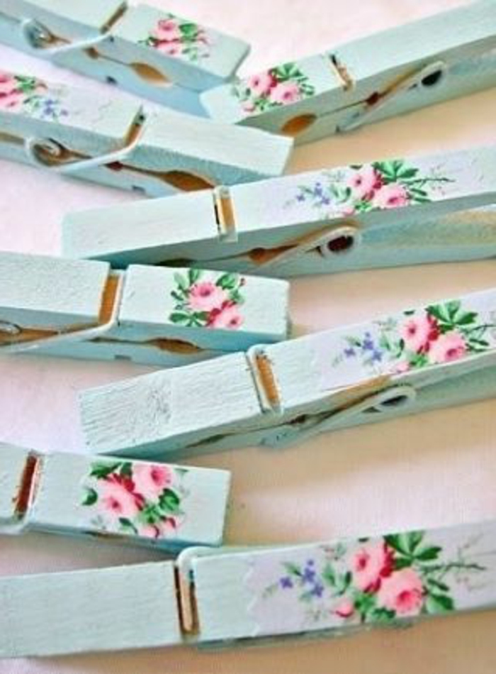 छोटे गुलाबी फूलों और हरे पत्ते के साथ नैपकिन के साथ सुंदर कपड़ेपिन