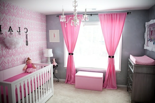 玫瑰色的窗帘和玻璃吊灯在婴儿室