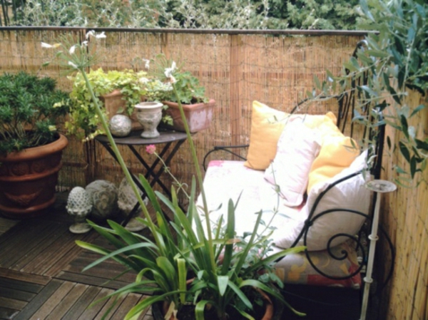 balcón-sichschutz-bambú verde de plantas decorativas-almohadas-on-the-sofá