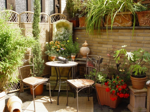 Σχεδιασμός βεράντας με πράσινα φυτά, στρογγυλό τραπέζι και δύο καρέκλες