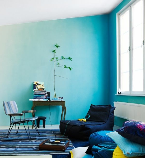 habitación pequeña con paredes azules sillón, alfombra