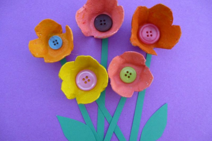 Carton d'oeuf bricolage avec des boutons et du livre vert - fleur colorée