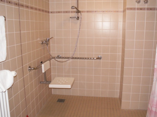 地板到天花板的淋浴间小浴室，瓷砖为桃色