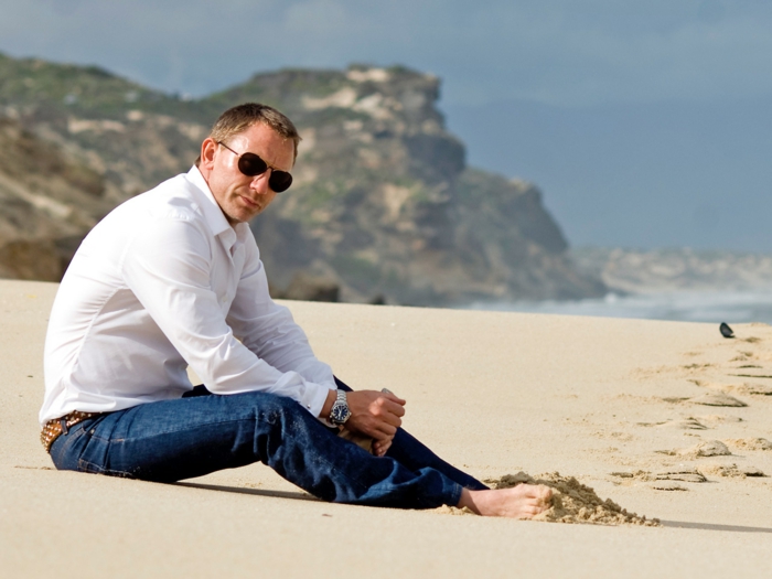 丹尼尔克雷格在沙滩上牛仔裤棕色带白色衬衫眼镜很棒的发型手表