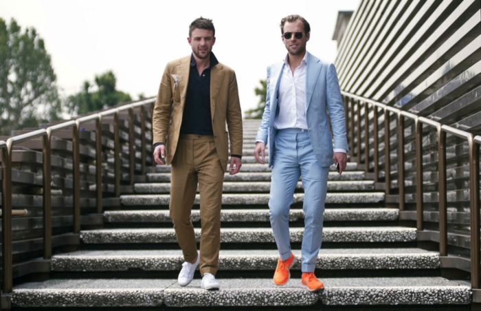 עמיתים שני גברים שותפים עסקיים לרדת במדרגות ללבוש נעלי ספורט וחליפה