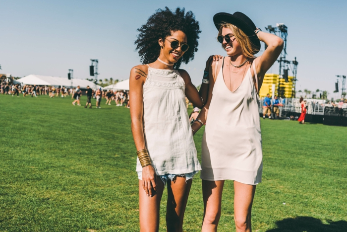 hippie festivalska odjeća Dvije lijepe žene zabavljaju se na zelenom polju slušajući glazbu i uživajući