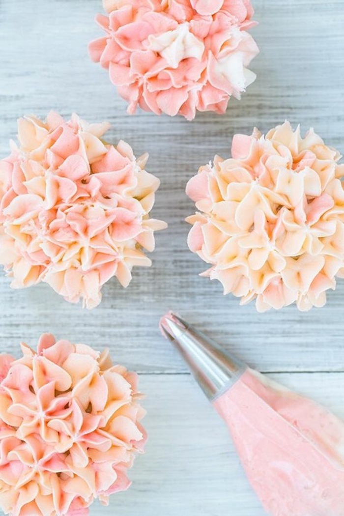 गुलाबी क्रीम के छोटे फूलों के साथ महान कपकेक सजावट