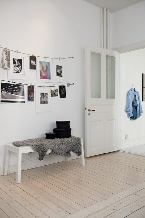 petit couloir avec un design mural blanc et des photos suspendues