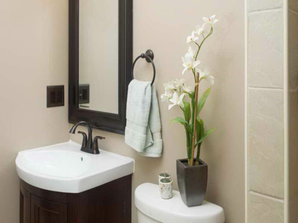 带兰花装饰的现代浴室配有美丽的镜子