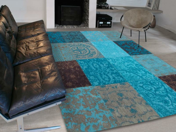 decoración en color turquesa, alfombra moderna y atractiva al lado de un sofá de cuero