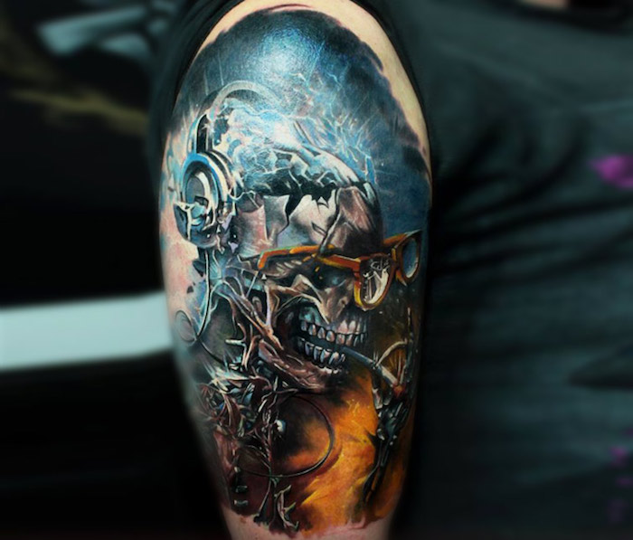 Una mano con un colorido tatuaje azul con un cráneo de metal y gafas y un cigarrillo