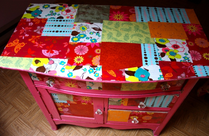 vaaleanpunainen kaappi, jossa on värikkäät lautasliinat kukilla ja perhosilla