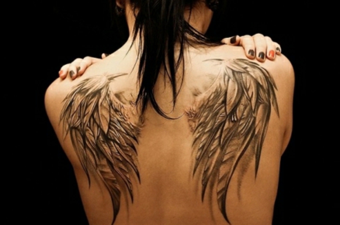一个拥有伟大天使翅膀纹身的女人 - 这里有两个带长长的黑色羽毛的大天使翅膀