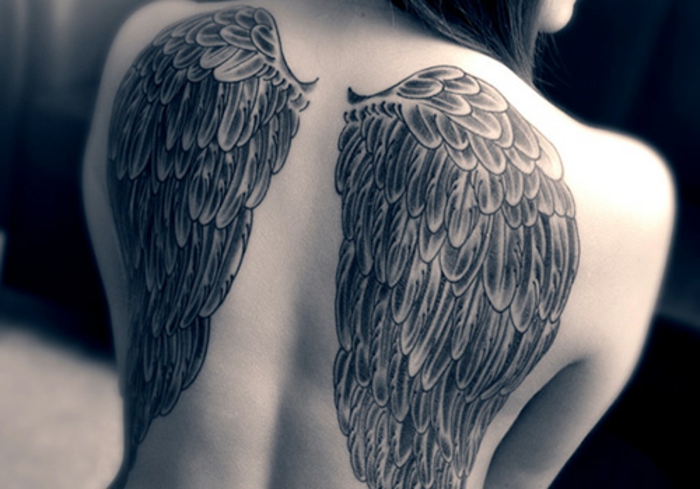 这是一个带长天使翅膀的大天使纹身的女人