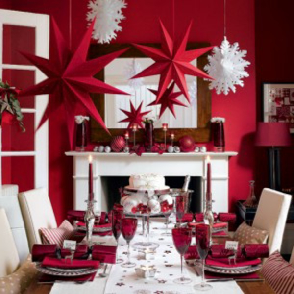 Elegantes decoraciones navideñas, estrellas rojas y escamas blancas colgando del techo