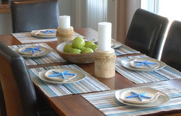 mesa de comedor con manzanas como decoración dos velas blancas grandes
