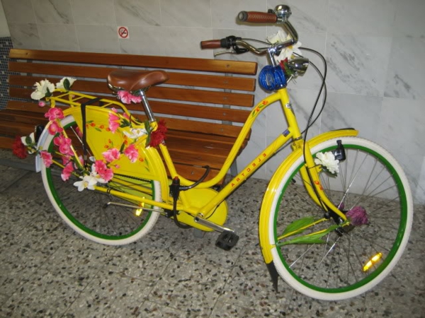 bicycle-deco-yellow-with-flowers - un banco marrón al lado