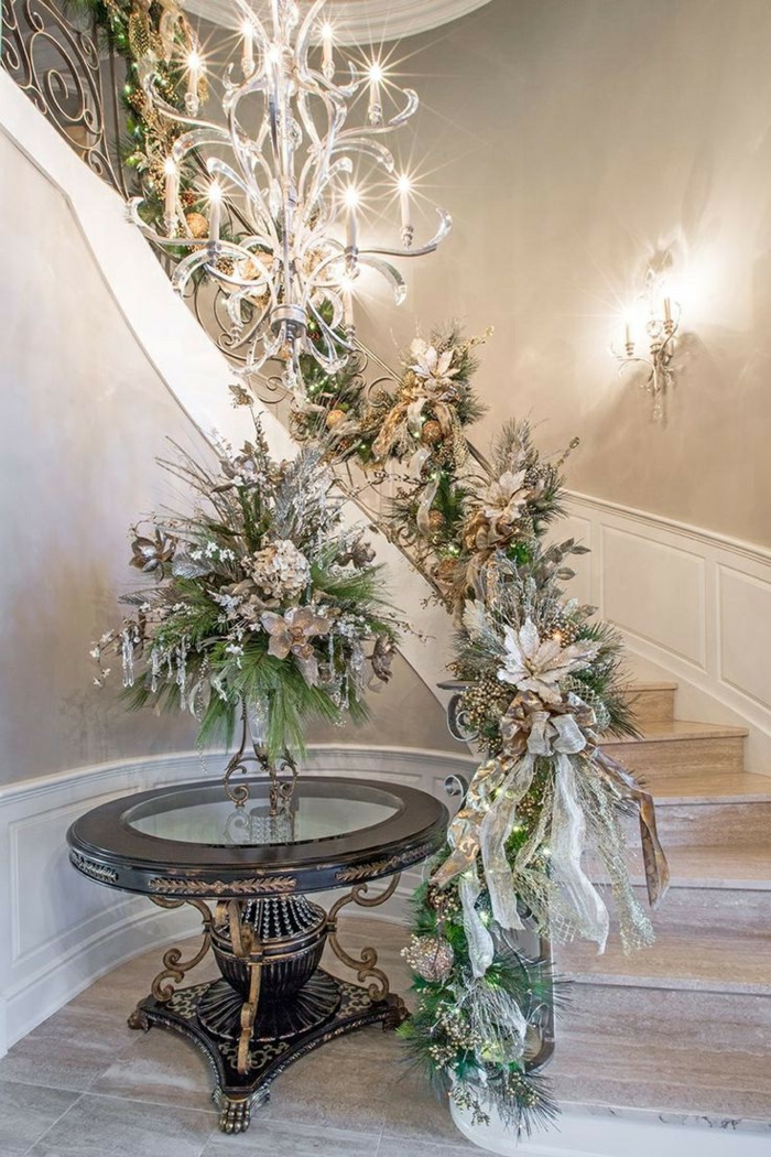 una brillante decoración de escalera para Navidad con ramas y flores