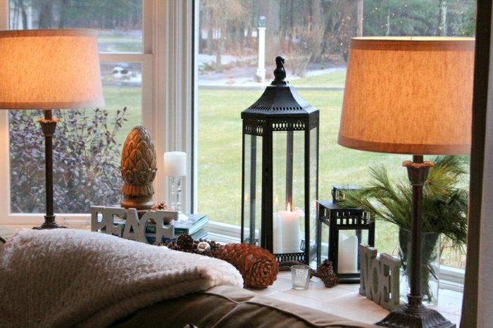 Las lámparas del alféizar de la ventana adornan la decoración con velas y conos