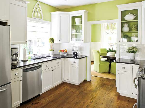 murs verts armoires blanches et éléments métalliques dans la cuisine