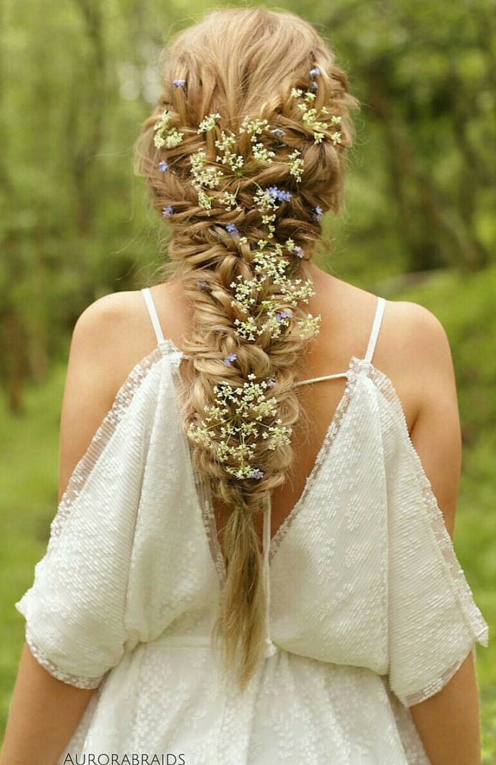 longs cheveux blonds tressés avec des fleurs fraîches tressées pour une coiffure parfaite