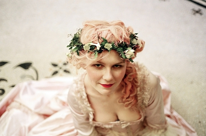 Kirsten Dunst avec des coiffures médiévales - couronne florale de roses blanches, cheveux roses