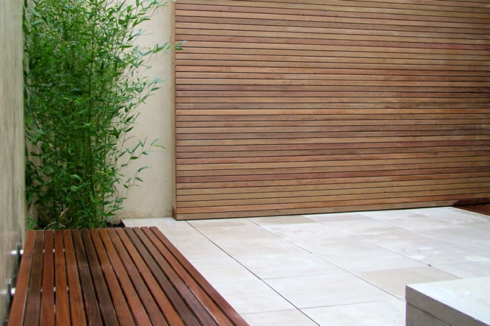 una pantalla de madera, un banco y una planta verde, pisos de baldosas - jardín minimalista