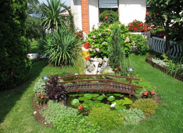 minimalistinen puutarha, jossa on pieniä liljoja ja viheralueita, joissa on silta