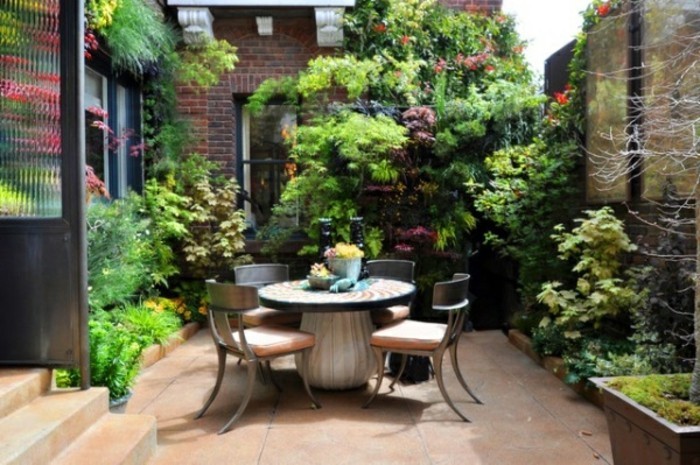 κήπος ιδέες-για-μικρά-κήπους-μικρής στρογγυλής τραπέζης-και-πολλά πράσινο φυτό