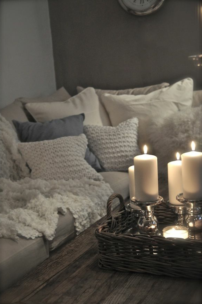 בסלון ספה נע גוונים רכים דגמים רבים סרוגים כרית אווירה רומנטית נרות