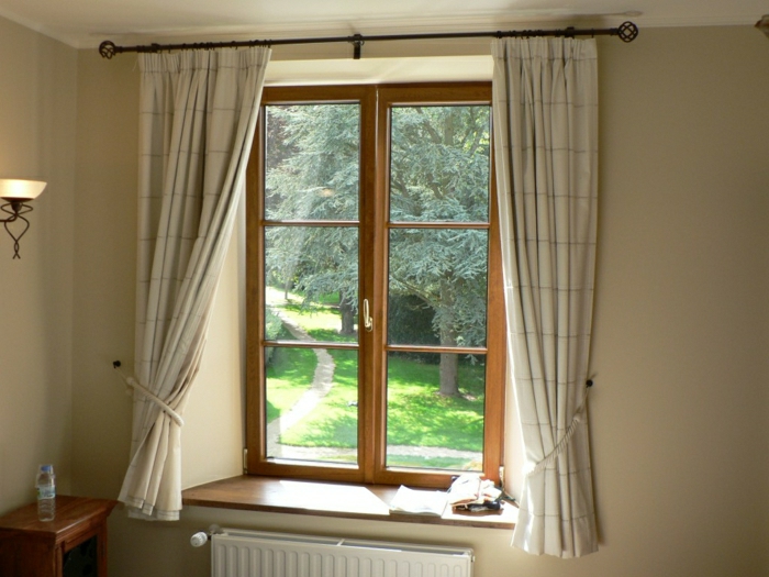 舒适的卧室散热器小窗口，木结构的窗帘，粉彩米色