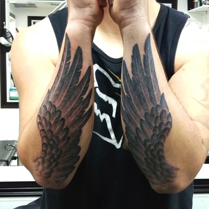 纹身双手的好主意 - 这里有两只手，两只长着羽毛的黑色天使翅膀