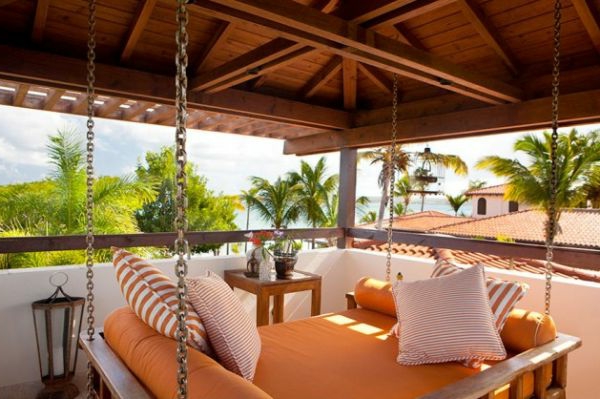 在美丽的景色的现代木制露台上的橙色吊床