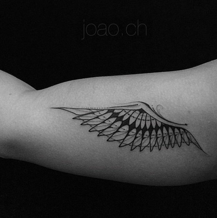 一只小黑天使翅膀纹身与长长的黑色羽毛的手