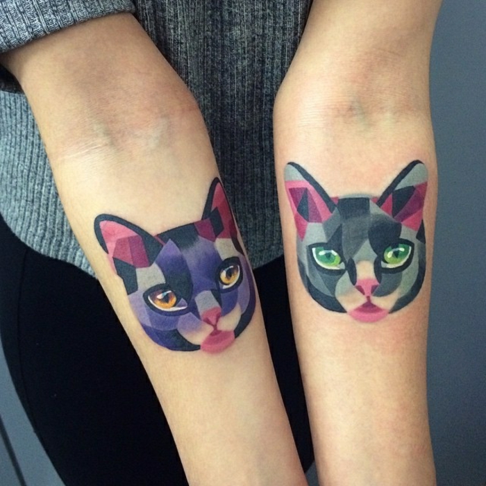 यहां हम आपको दो हाथों से रंगीन बिल्लियों टैटू मारते हैं-एक बिल्ली हरी आंखों और एक गुलाबी नाक और नारंगी आंखों के साथ एक बैंगनी बिल्ली