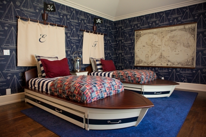 δύο κρεβάτια όπως τα πλοία με πανιά πάνω από αυτά με τα αρχικά του παιδιού - πειρατικό νηπιαγωγείο