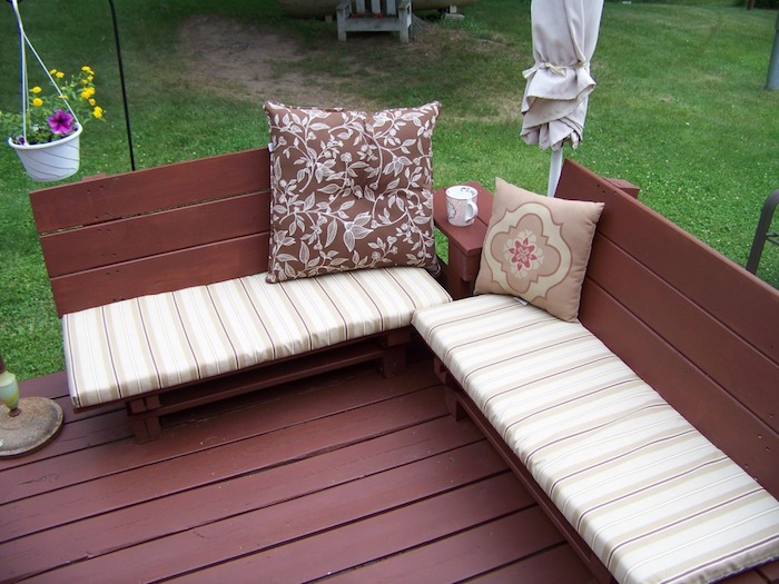 дървена градинска мебел - две кафяви градински пейки с две възглавници - саксия за цветя с виолетови и жълти цветя - градинска пейка се изграждат сами