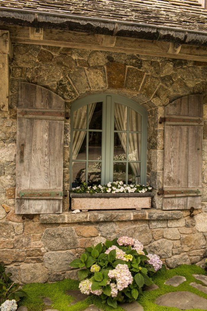 pequeña casa de piedra paredes Norman-maceta de flores ventana de la arquitectura de madera del obturador