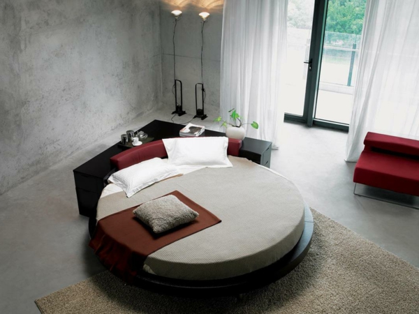 小卧室，一个漂亮的圆床灰色的墙壁和白色的窗帘