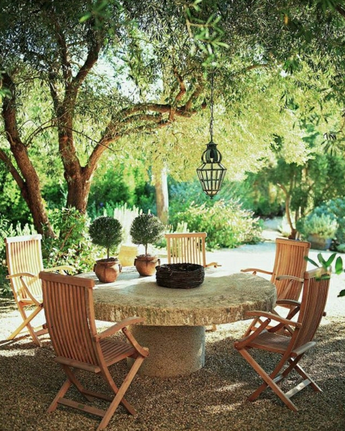 Välimeren-puutarhan suunnitteluun-kivipöydän-puiset tuolit-lyhty