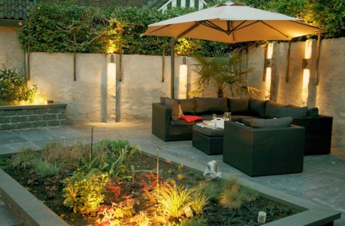 Jardín Purist: jardín bien iluminado con muchas plantas verdes y elegantes muebles de jardín
