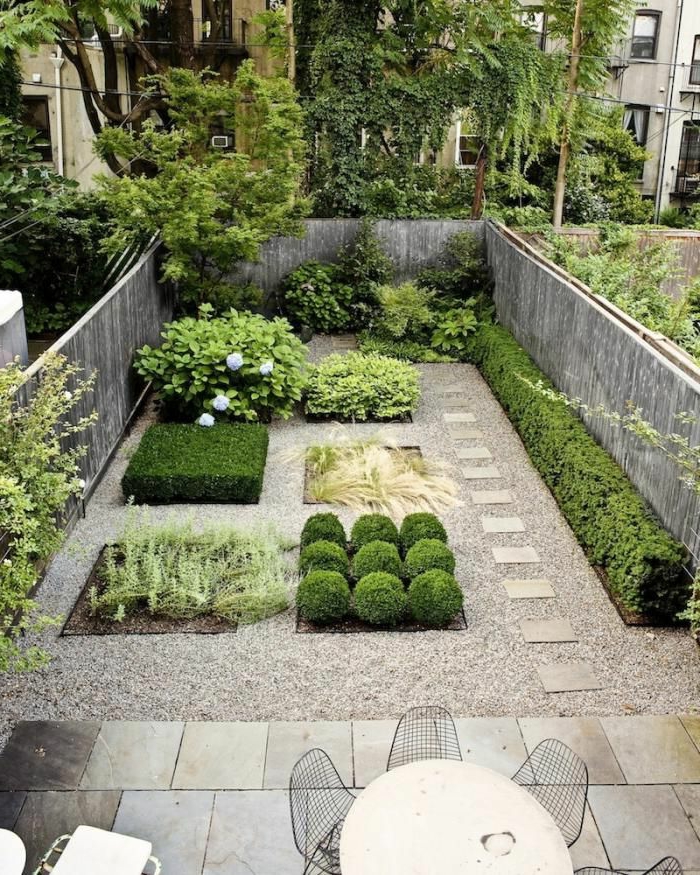 jardín verde con varias camas de flores - un pequeño jardín delantero moderno