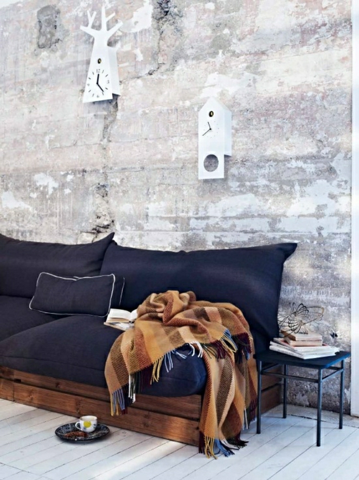 minimalist इंटीरियर-स्थानिक-रूम पैलेट काउच नीली असबाबवाला पुराने कंबल दीवार घड़ियों-ईंट की दीवारों