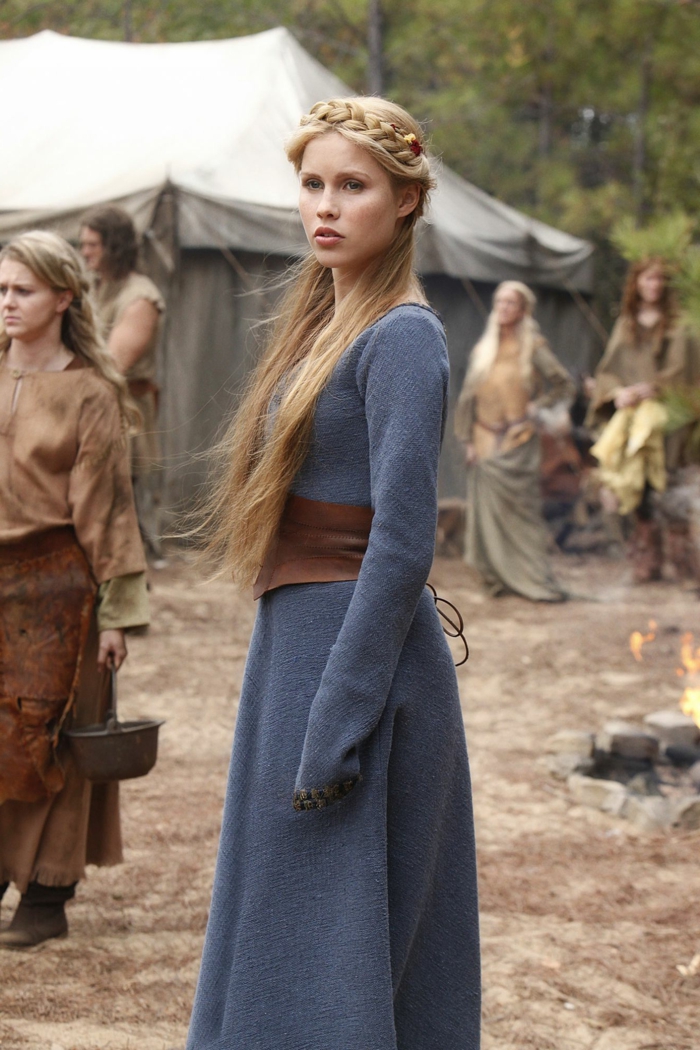 fille blonde avec une coiffure tressée dans un film médiéval avec une robe bleue